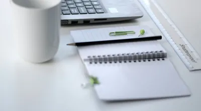 stock image of a notebook, mug and laptop